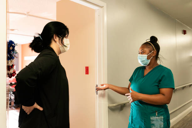 Two CNAs talking in a hallway at work, Midwest, Indiana, USA